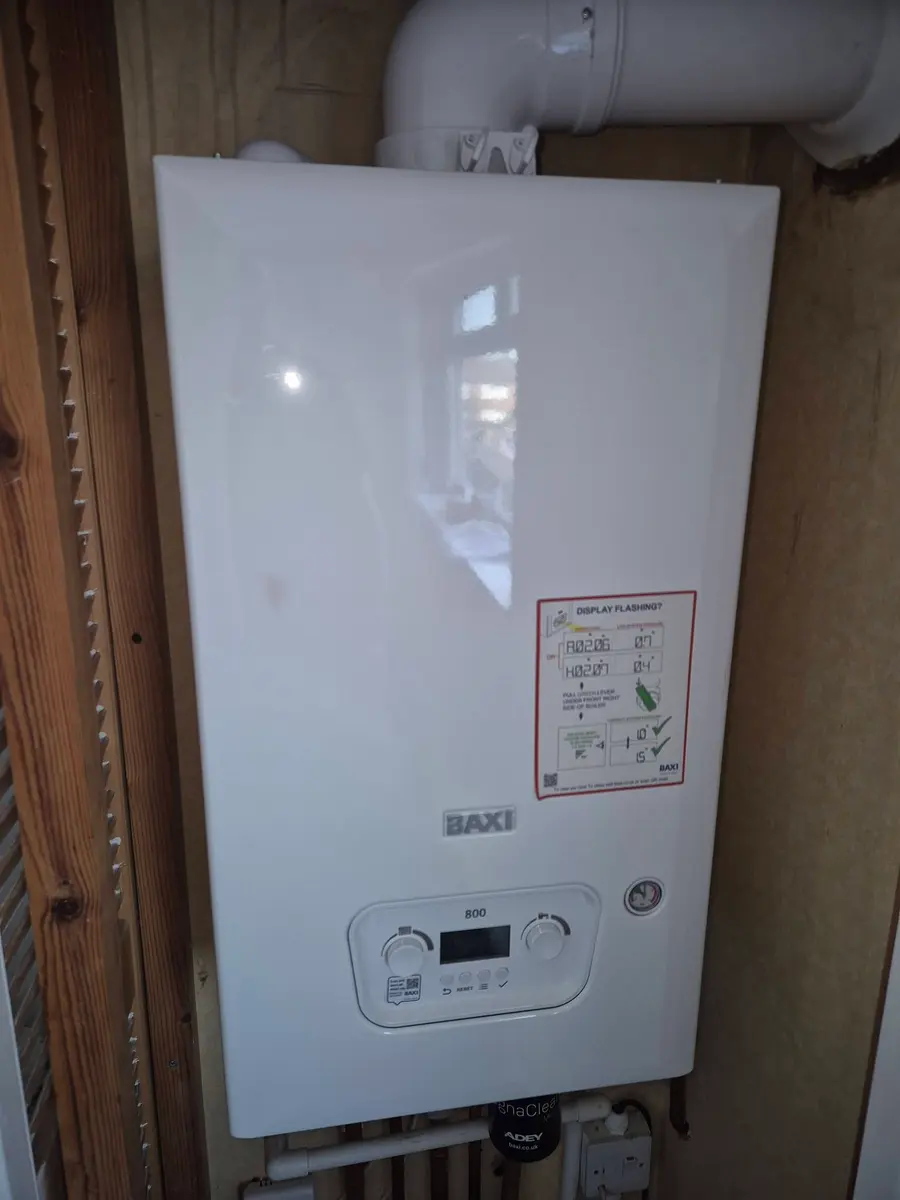 New Baxi combi boiler fitted on a timber-lined wall